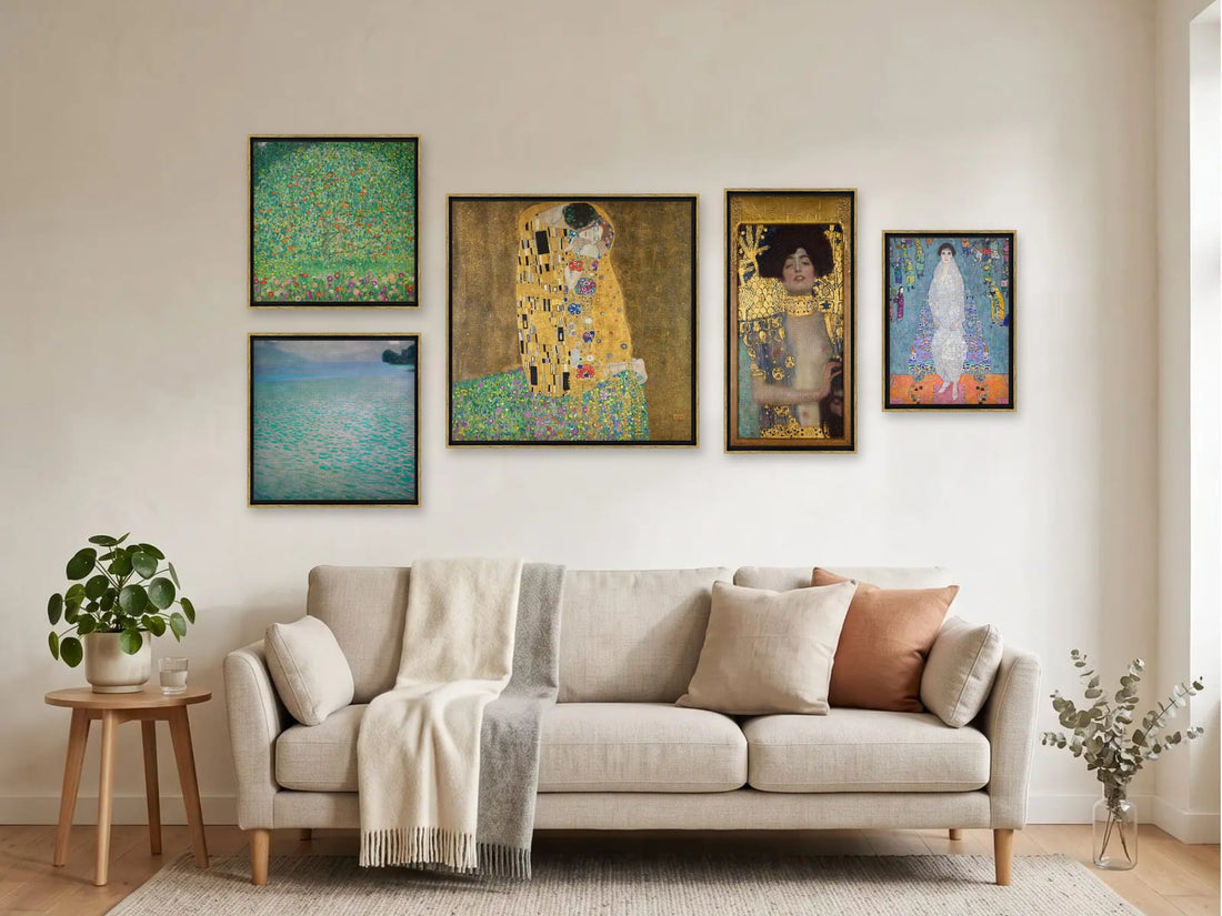 Bilderwand „Klimt in Gold“ mit dem Kuss und weiteren Werken von Gustav Klimt über einem hellen Sofa im Wohnzimmer